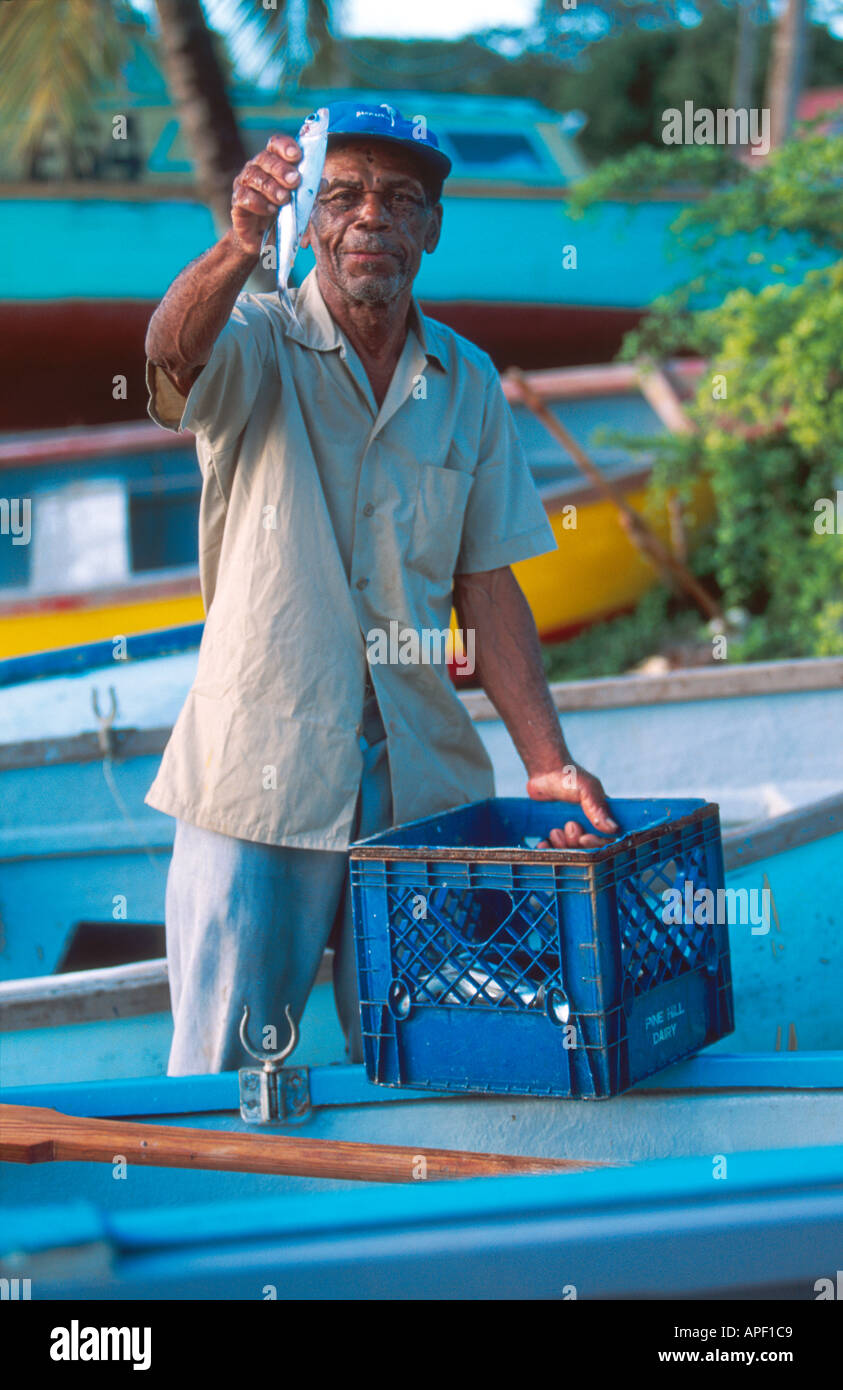 Fisherman tenendo la sua cattura pesci volanti Speightstown Mercato del Pesce Barbados Indie occidentali Foto Stock