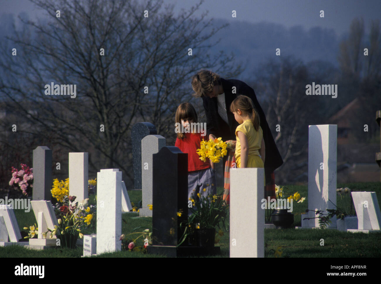 Madre e figli in un cimitero Foto Stock