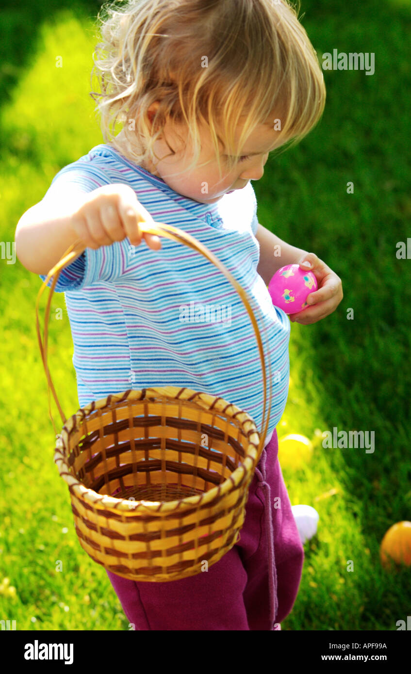 Due anni di ragazza con cesto di pasqua e rosa uovo di pasqua Foto Stock