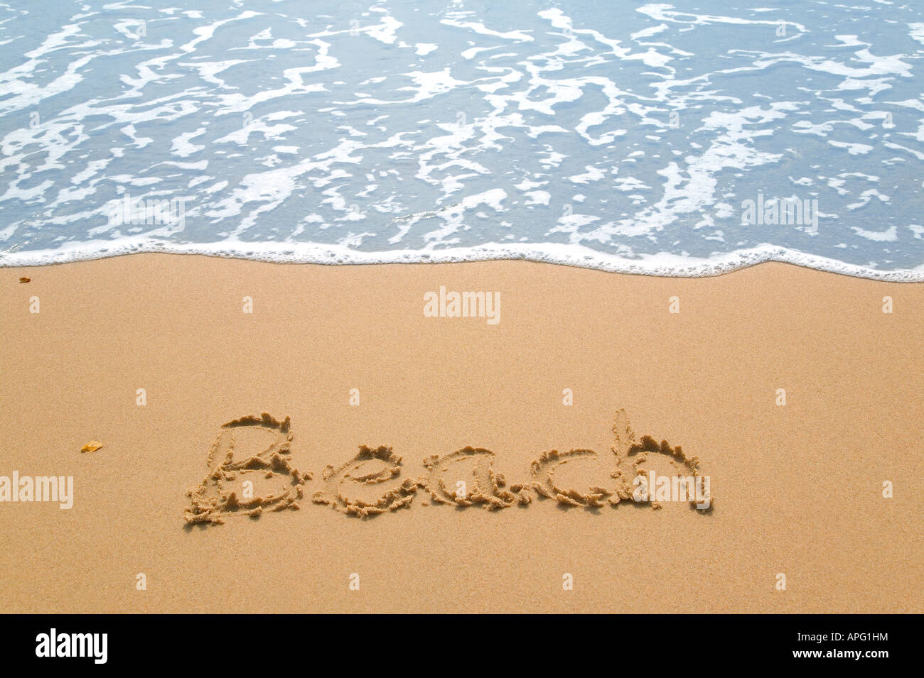 Spiaggia scritto su una spiaggia di sabbia dorata accanto al bordo delle acque Foto Stock