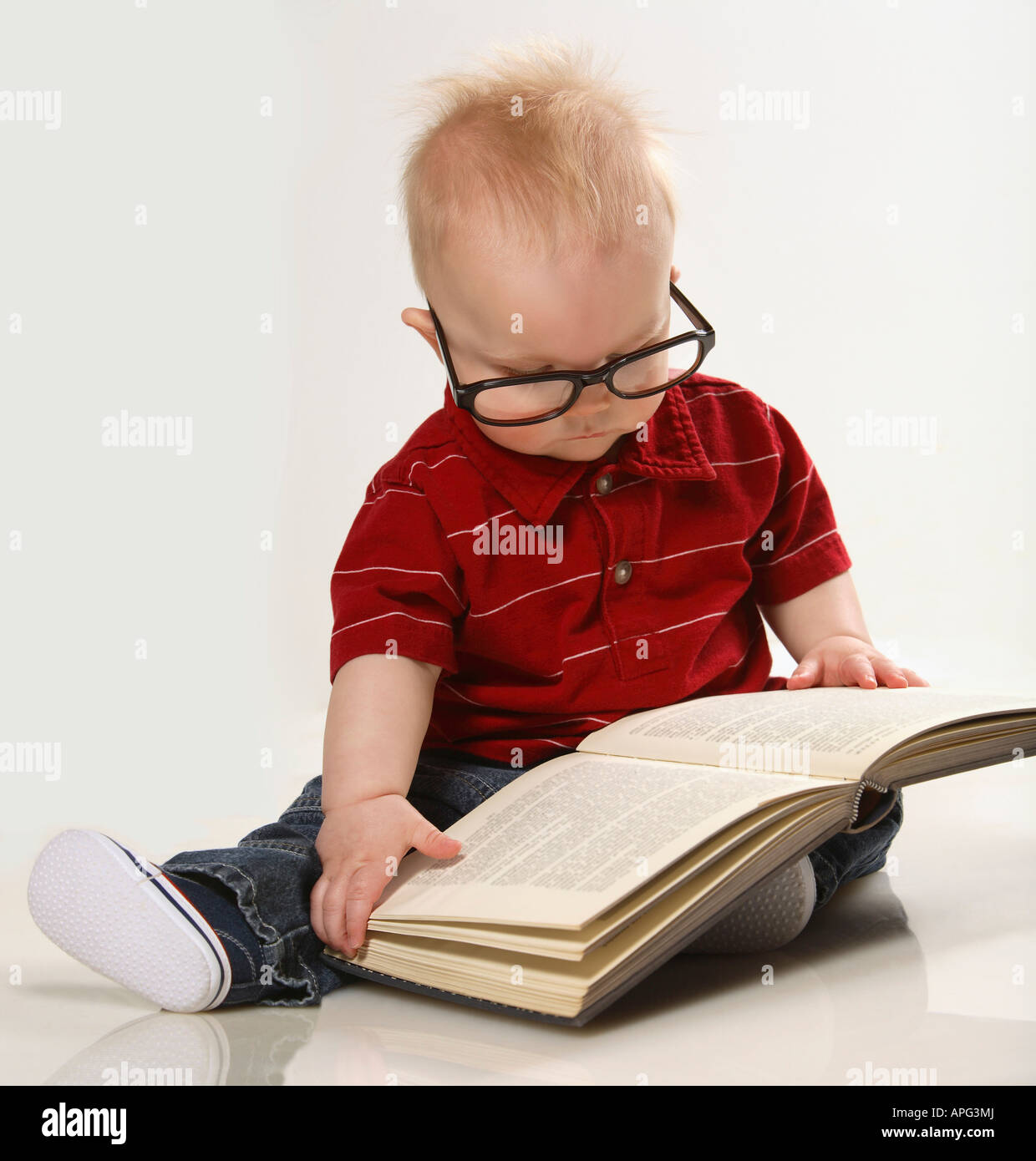 Un bambino guardando un libro Foto Stock