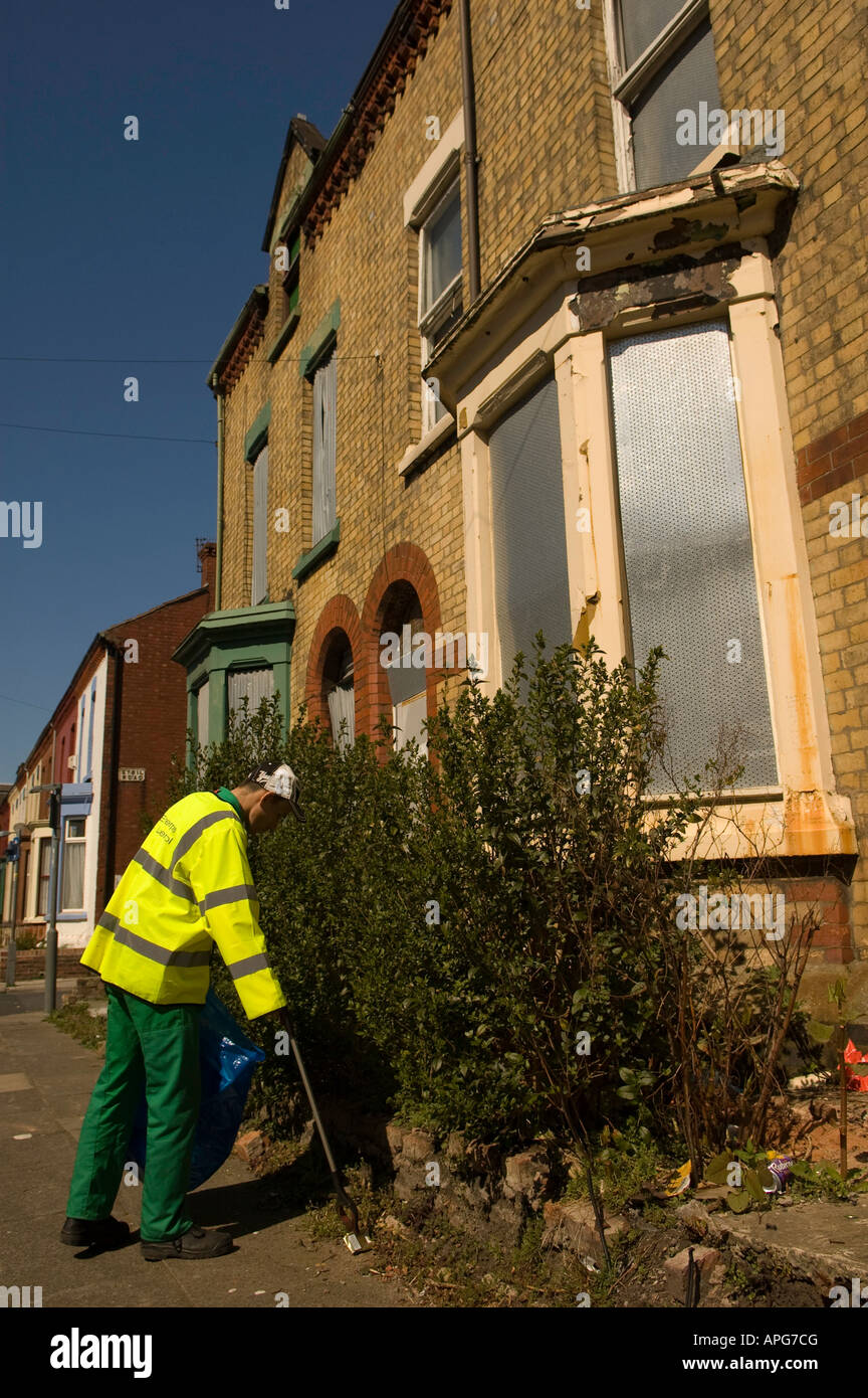 Consiglio pulizia operativa fino a vecchi malandato street in un sobborgo di Liverpool England Foto Stock