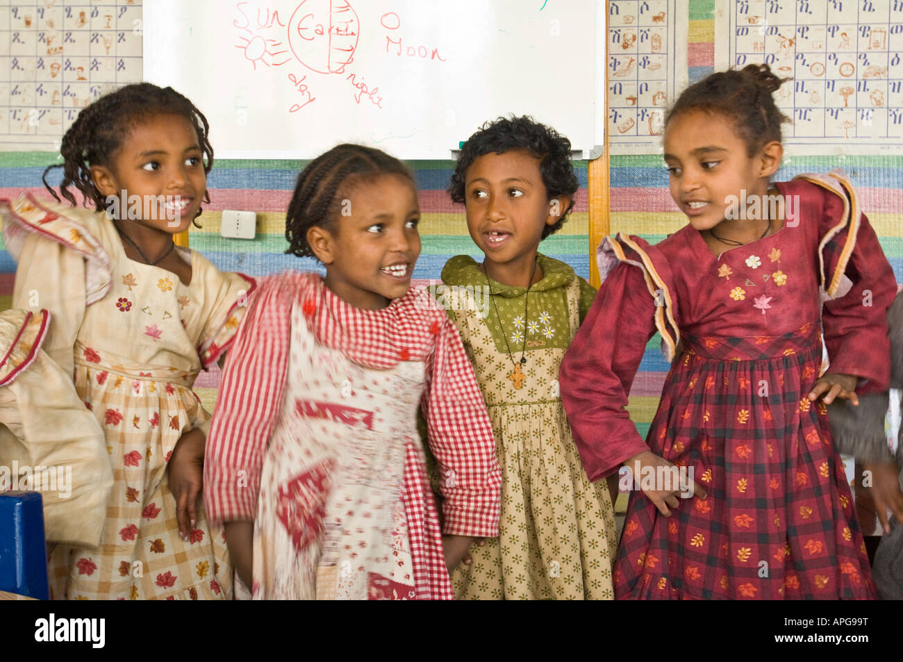Bambini cantano una canzone con azioni per le parole in aula di una carità eseguire scuola. Foto Stock