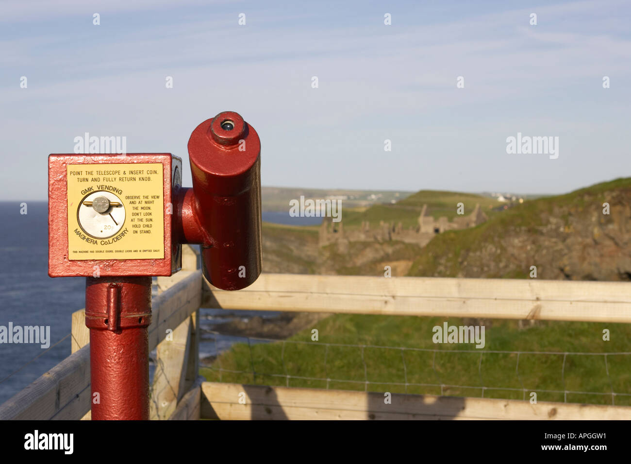 Rosso e giallo pay per view a gettone telescopio per turisti in cerca verso Dunluce Castle nella contea di Antrim Irlanda del Nord Foto Stock