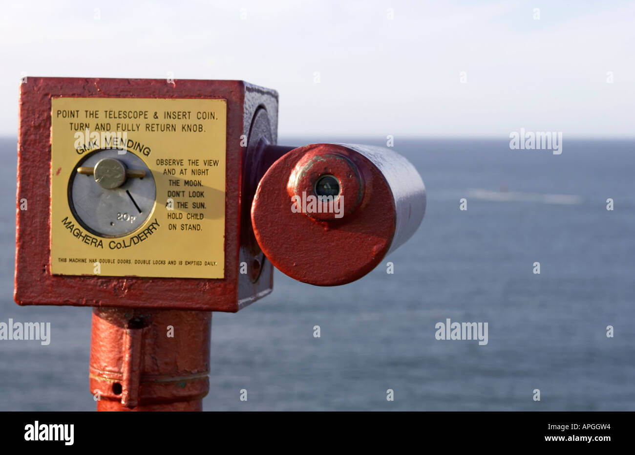 Rosso e giallo pay per view a gettone telescopio per turisti che guarda all'oceano atlantico County Antrim Foto Stock