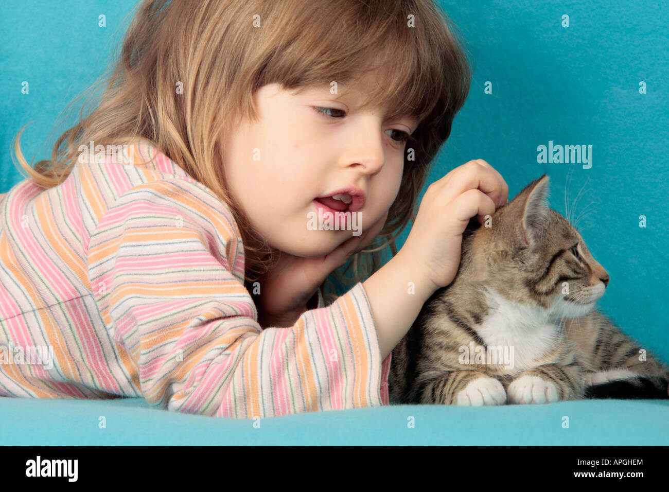 Ritratto di una giovane ragazza fondling un gattino Foto Stock