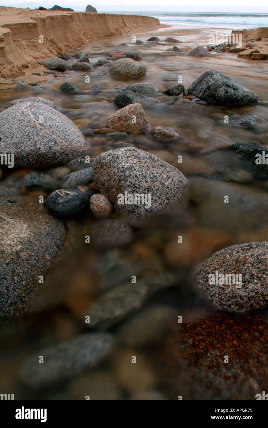 Boulder disseminata fiume che scorre nell'Oceano Pacifico, Garrapata Beach, California, Marzo Foto Stock