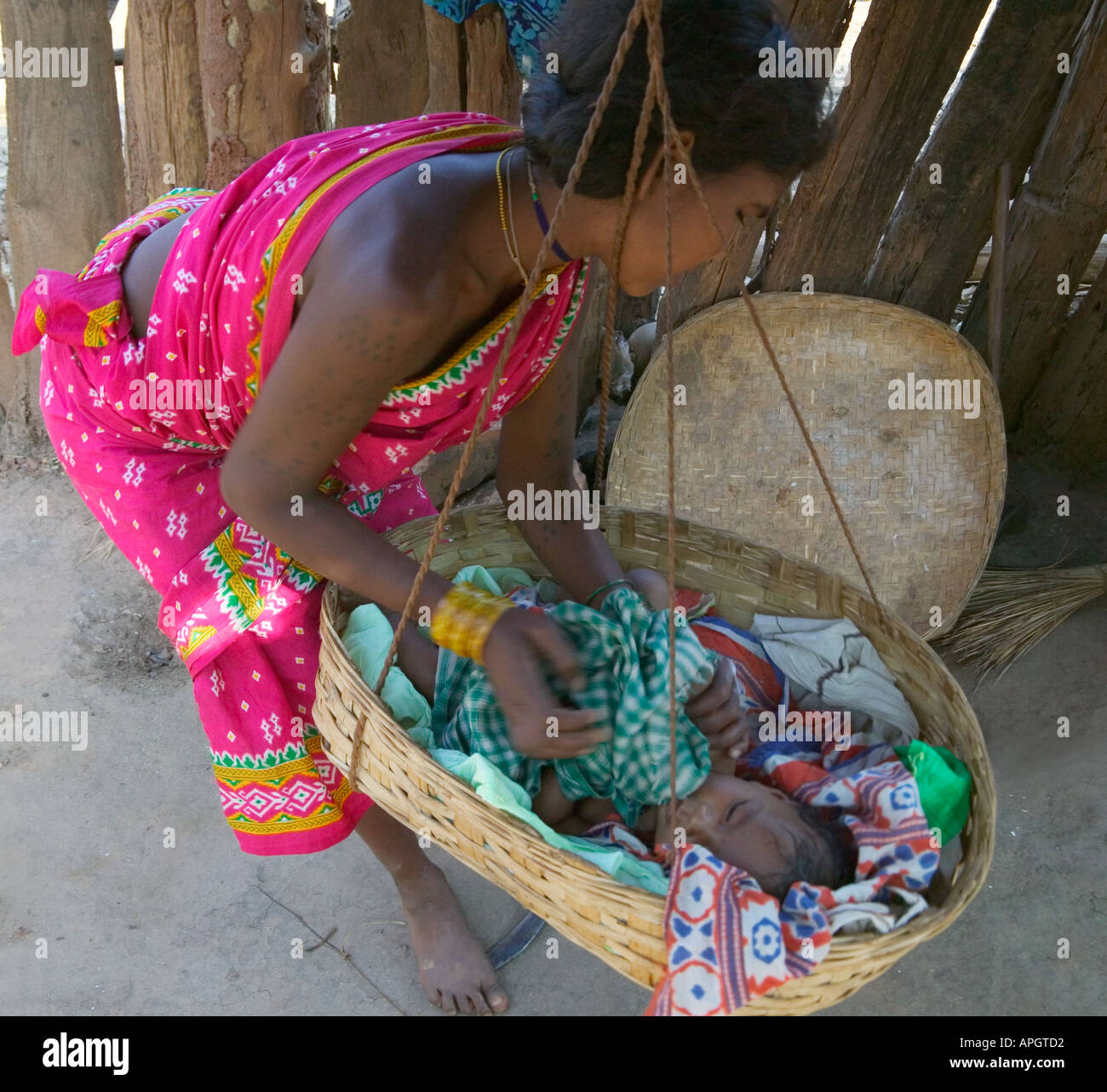 Hill tribeswoman con il bambino nel presepe nel villaggio di Orissa India Foto Stock