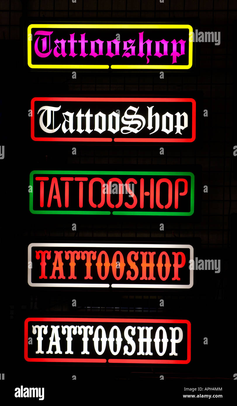 Un sacco di multi-neon colorati tattoo shop segni illuminare le strade. Foto da Jim Holden. Foto Stock