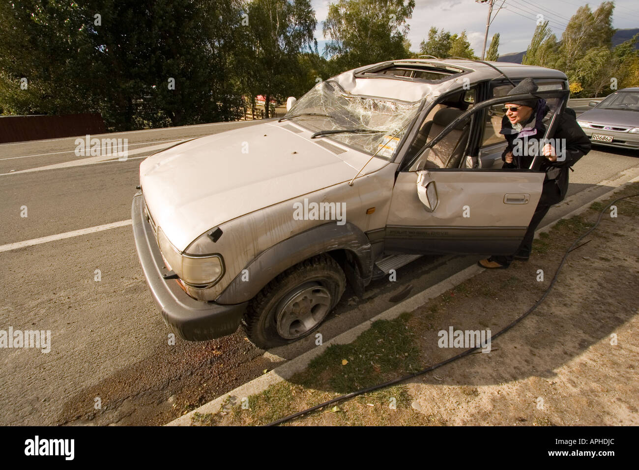 Nuova Zelanda esaminando driver danneggiato o soggetto ad atti vandalici auto sulla strada Foto Stock