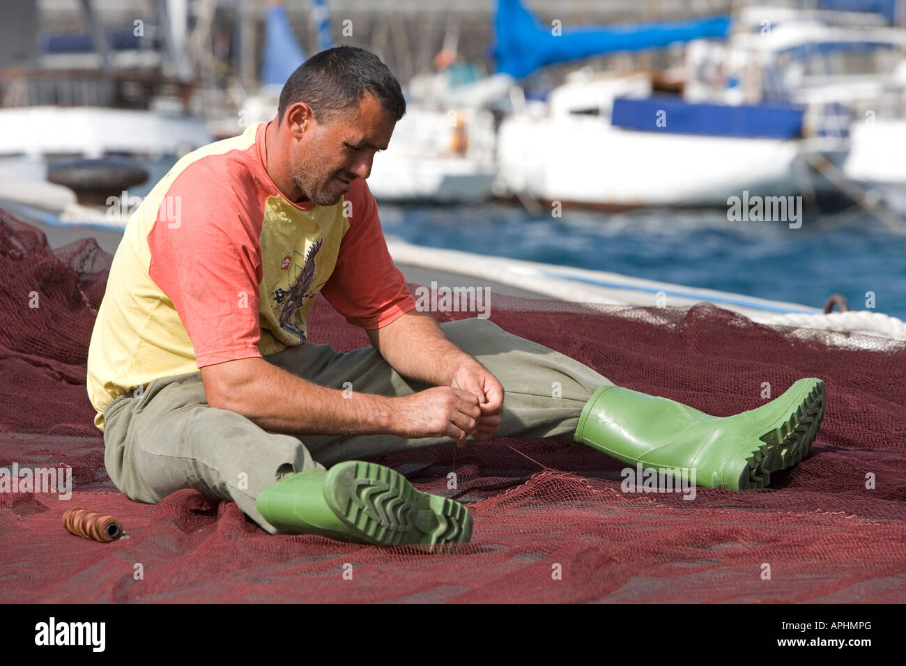 Spagna Isole Canarie La Gomera, pescatore nel porto Vueltas nella Valle Gran Rey sta riparando il suo volato Foto Stock