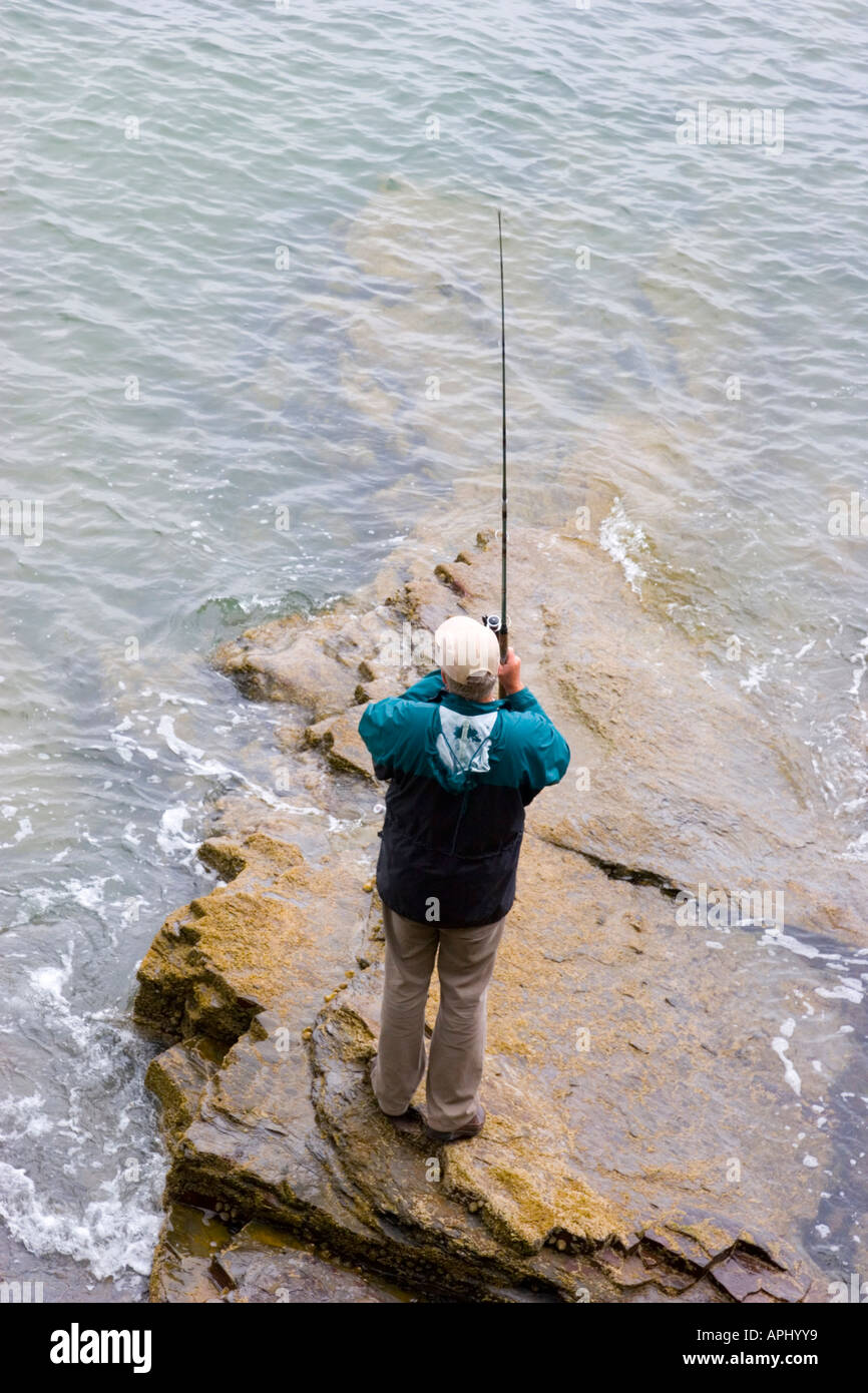 La pesca in mare dalle rocce e le difese del mare Foto Stock