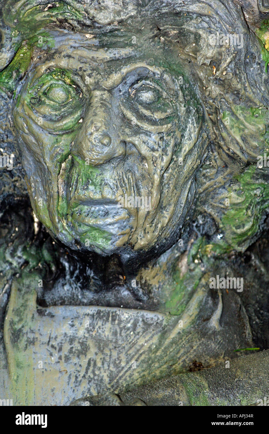 Maschera grottesca scolpita nella struttura ad albero orribile scary spaventoso faccia tagliata fuori della corteccia scolpito minaccioso facce maschere Foto Stock