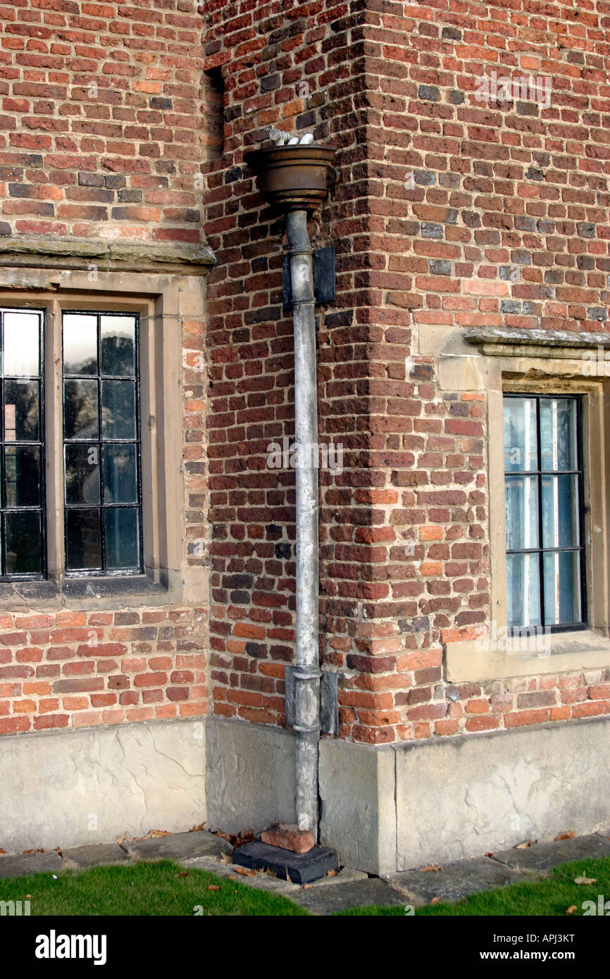 Scarico e tubo verso il basso, nei pressi di due originali di Windows. Costruito nel 1500 probabilmente il primo mattone nella costruzione nel Nottinghamshire. Holme Pierrepont Hall di Nottingham, Regno Unito Foto Stock