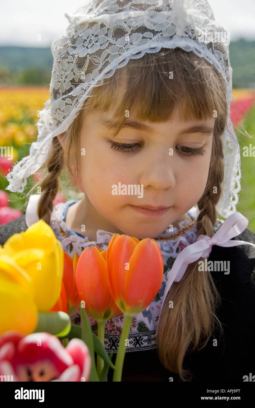 Giovane ragazza che indossa un cappello olandese tenendo i tulipani Foto Stock