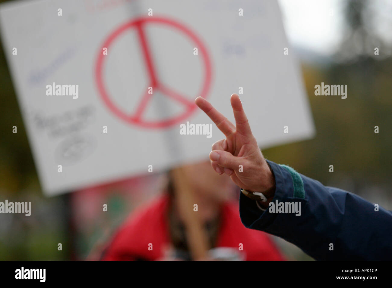 Un manifestante fa un 'pace' firmare in un rally Foto Stock
