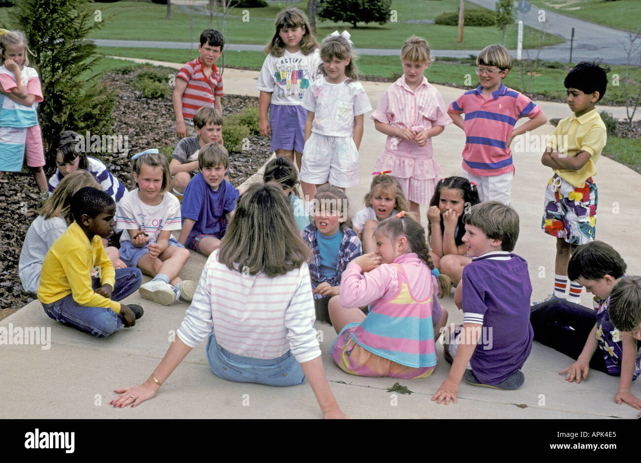 La seconda classe di qualità ascolta come il loro insegnante racconta storie in una classe esterna Foto Stock