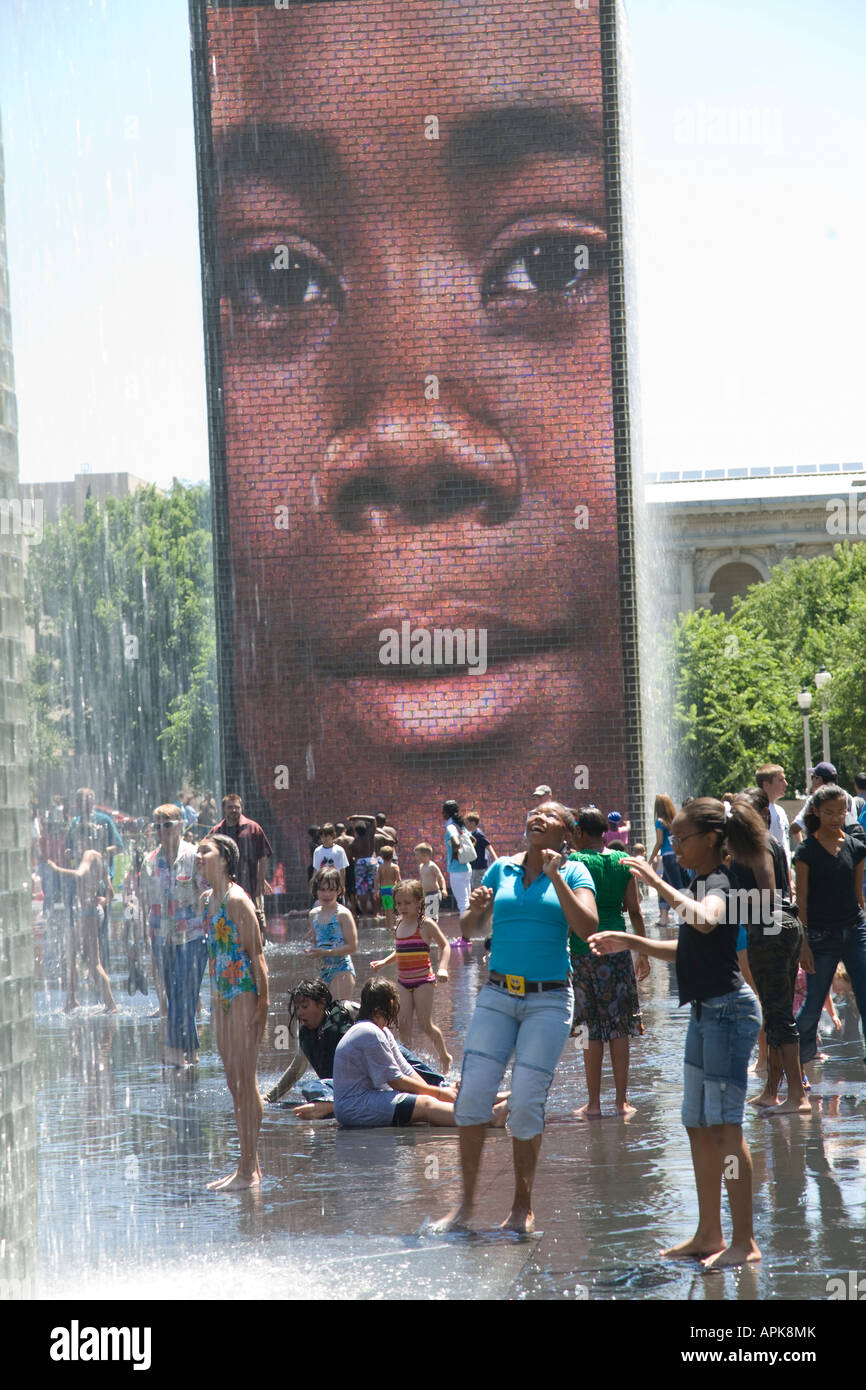 ILLINOIS Chicago adulti e bambini giocare in acqua dalla fontana di corona in Millennium Park faccia sul grande schermo video Foto Stock