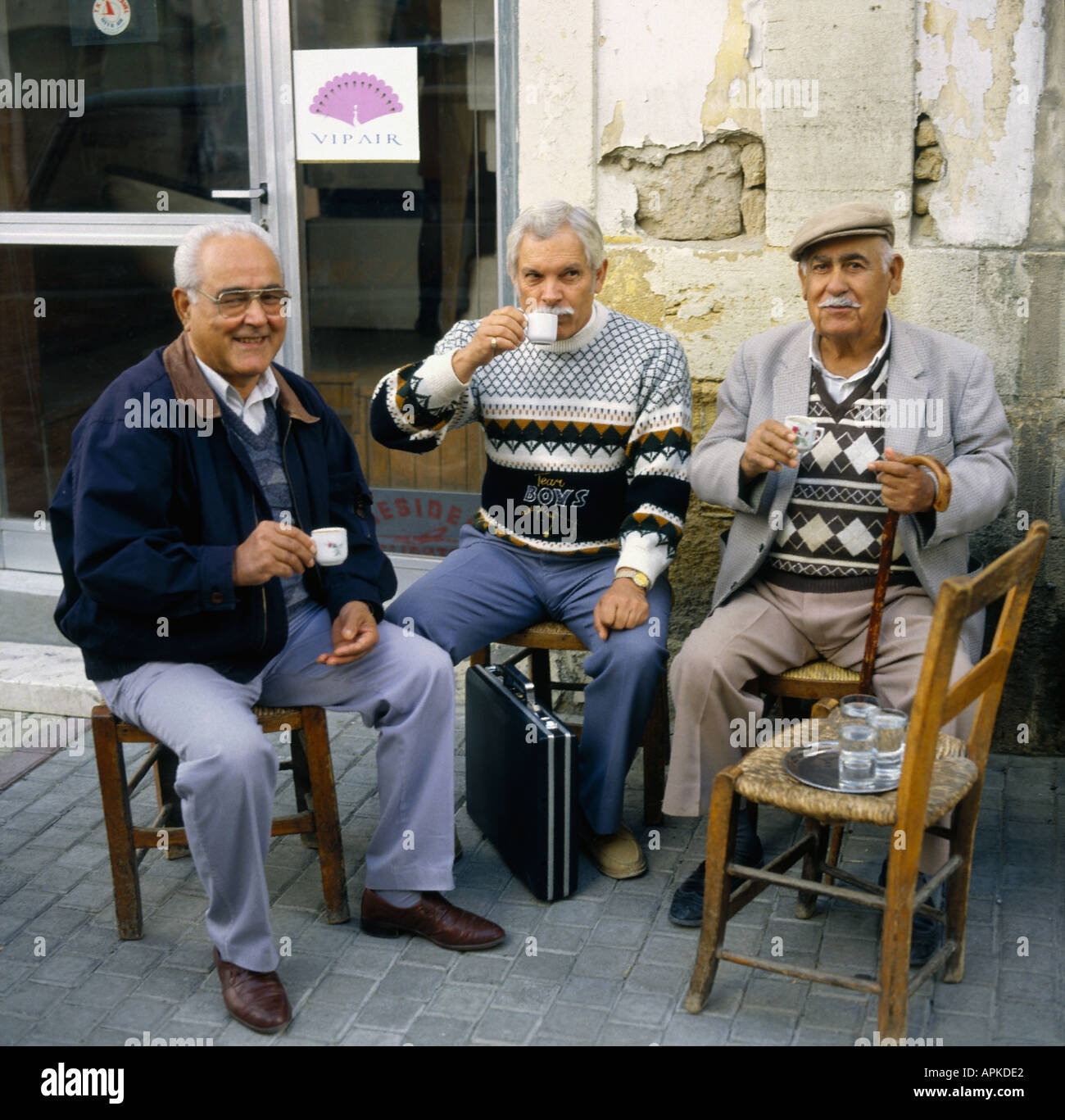 Un gruppo di tre locali bagno turco-cipriota uno degli uomini con valigetta ai suoi piedi relax di bere il caffè in Nicosia Cipro del Nord Foto Stock