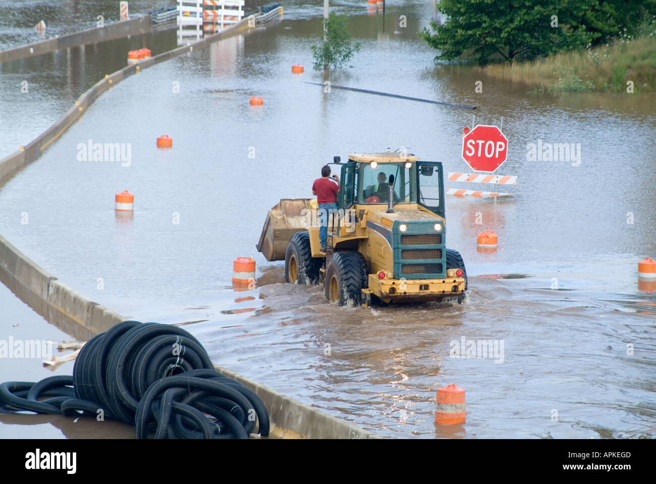 Uomini a cavallo in trattore attraverso la strada allagata, Pennsylvania, STATI UNITI D'AMERICA Foto Stock