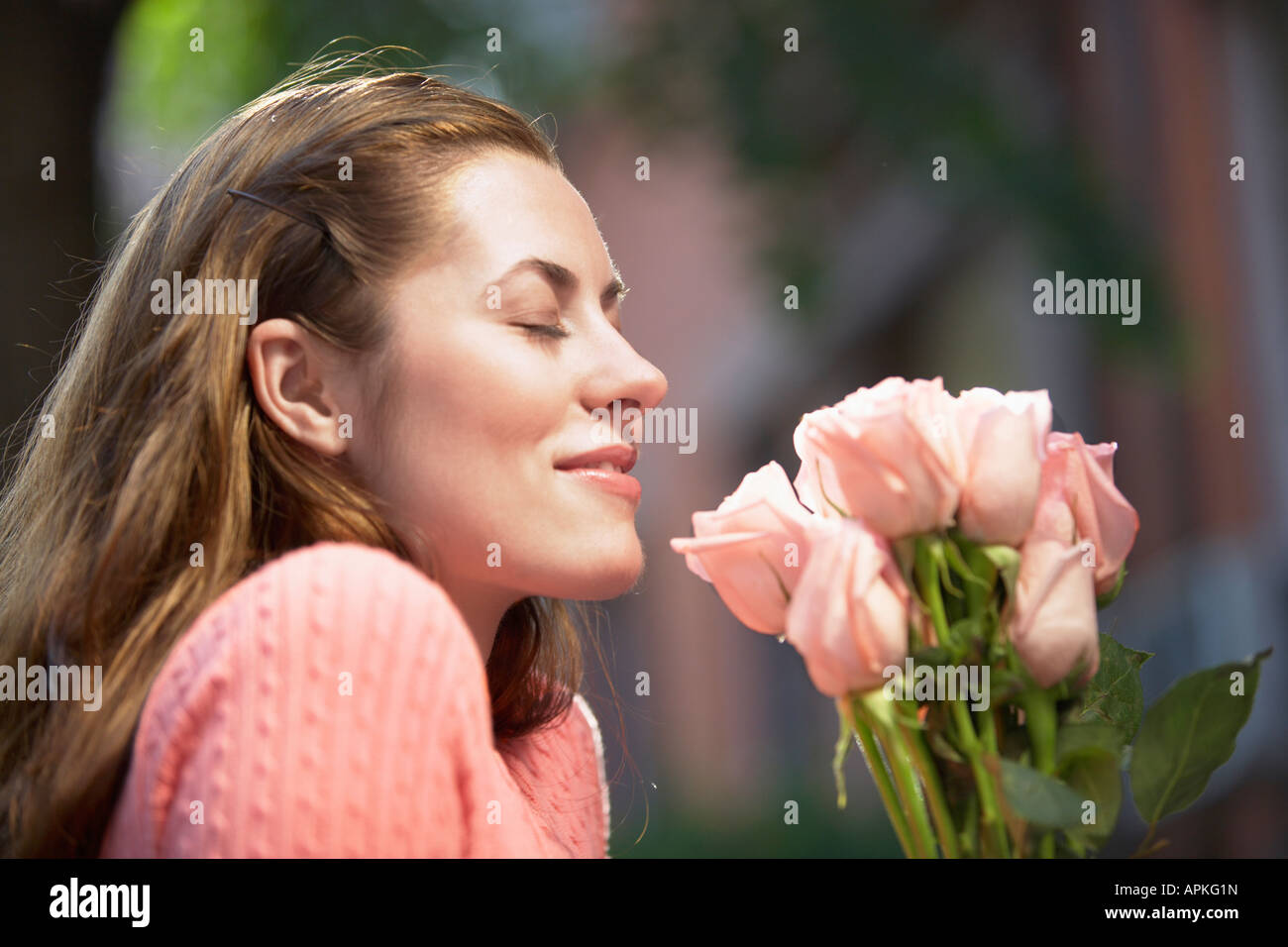 Giovane donna odore di rose (profilo) Foto Stock