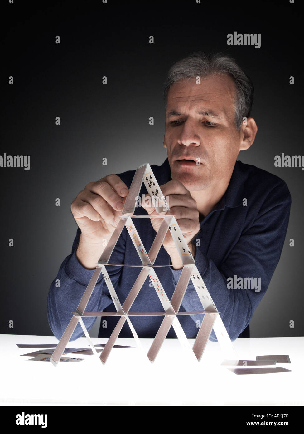 Uomo maturo la costruzione di casa delle carte Foto Stock