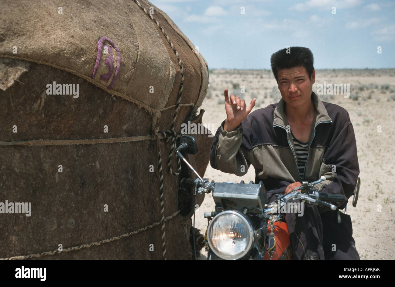 Il kazako pastore con un motociclo oltre ad una yurt, Kazakistan, Kyzyl Kum Foto Stock