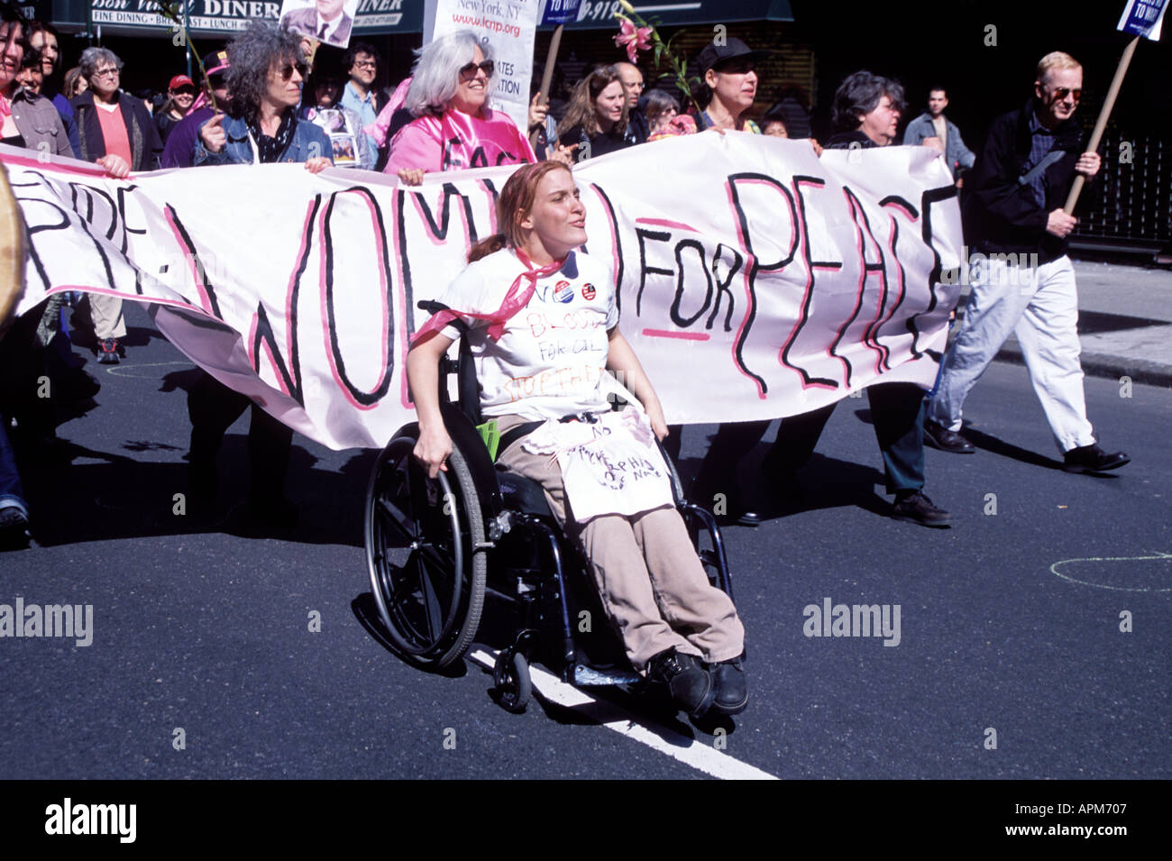 Una donna su una sedia a rotelle porta rosa di codice di un gruppo di donne per la pace marzo 22 Marcia della pace contro la guerra in Iraq New York City Foto Stock
