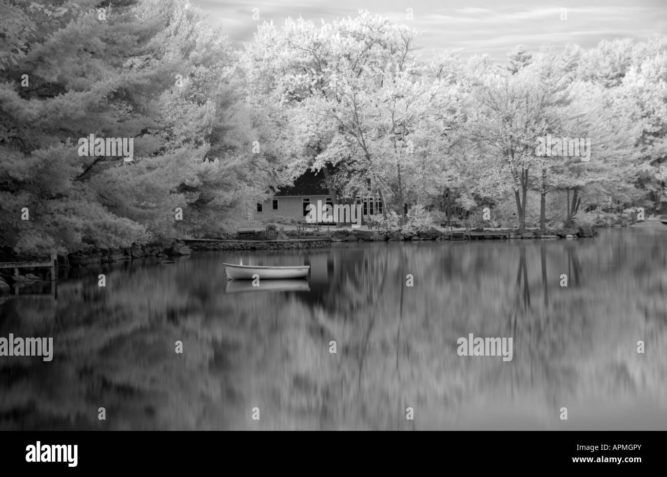 La tranquilla atmosfera scena di lago e la piccola barca nel lago Lungo Bridgton nel Maine nel New England in alternativa a infrarossi processo di pellicola Foto Stock