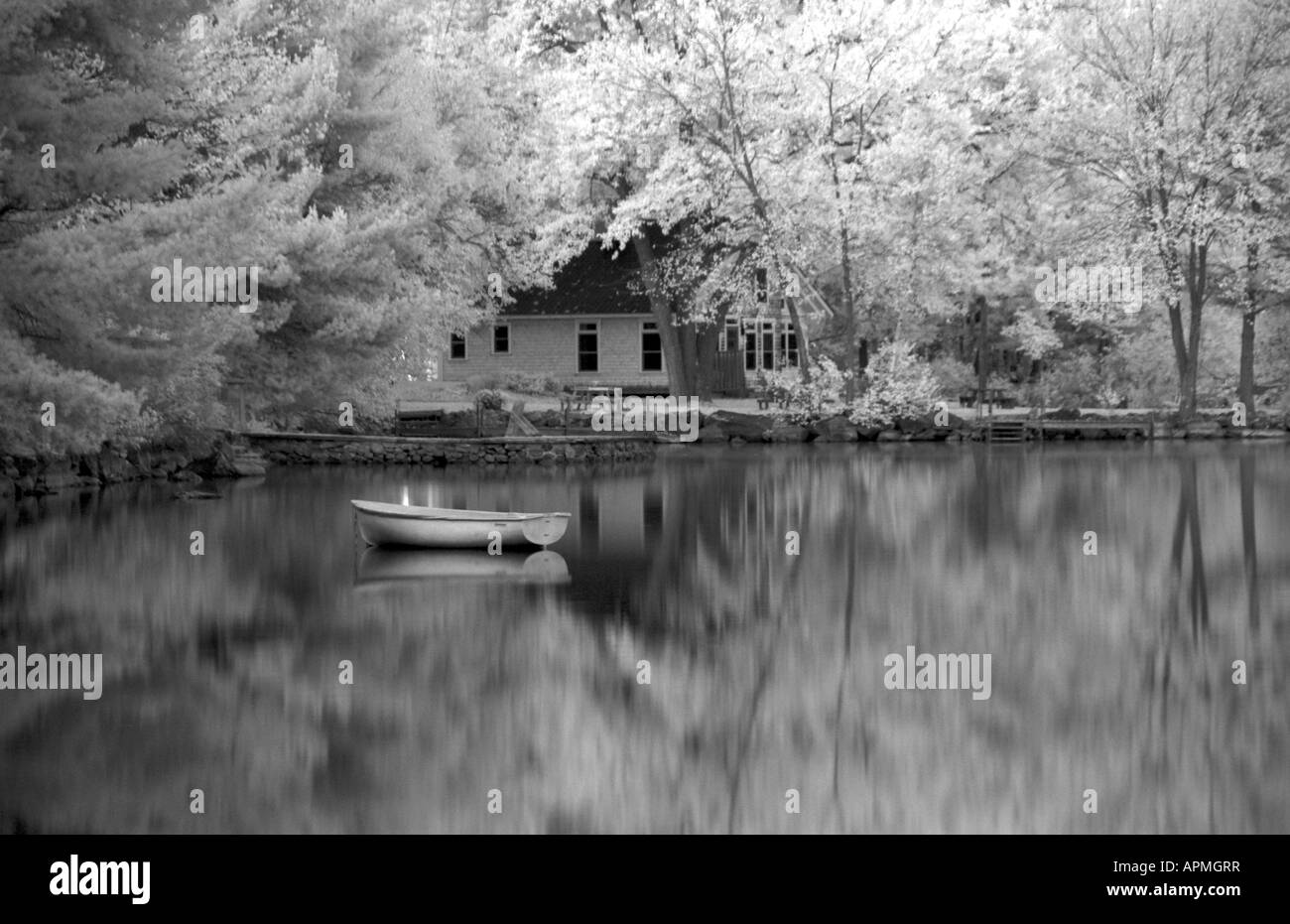 La tranquilla atmosfera scena di lago e la piccola barca nel lago Lungo Bridgton nel Maine nel New England in alternativa a infrarossi processo di pellicola Foto Stock