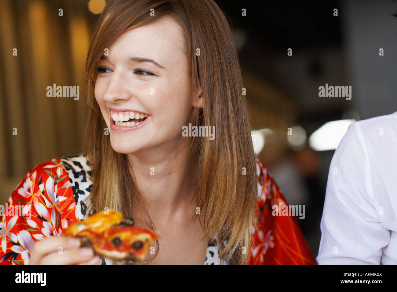 Giovane donna di mangiare la pizza in cafe Foto Stock