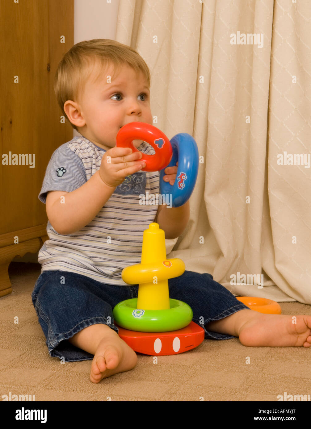Bambino di undici mesi giocando con anelli graduata Foto Stock