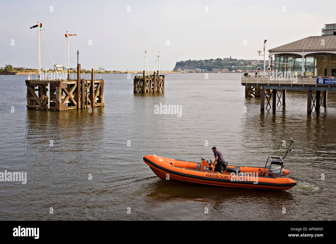 Harbour patrol le imbarcazioni gonfiabili in Cardiff Bay con la vecchia ferrovia e segnali Penarth testa in distanza Cardiff Wales UK Foto Stock