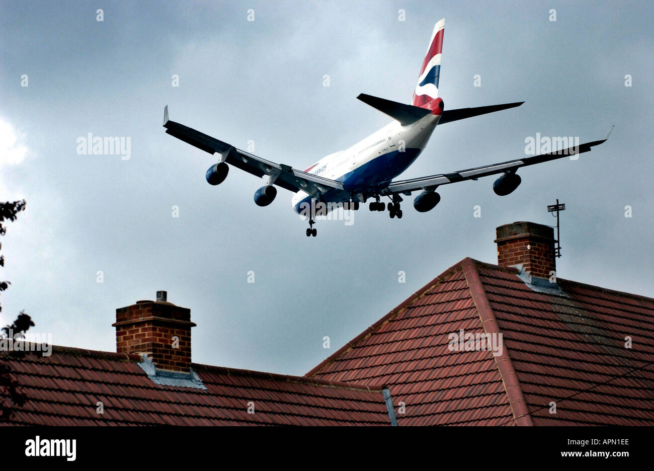 Bassa battenti British Airways jet sfiora i tetti che si avvicina all'aeroporto Heathrow di Londra. Foto Stock