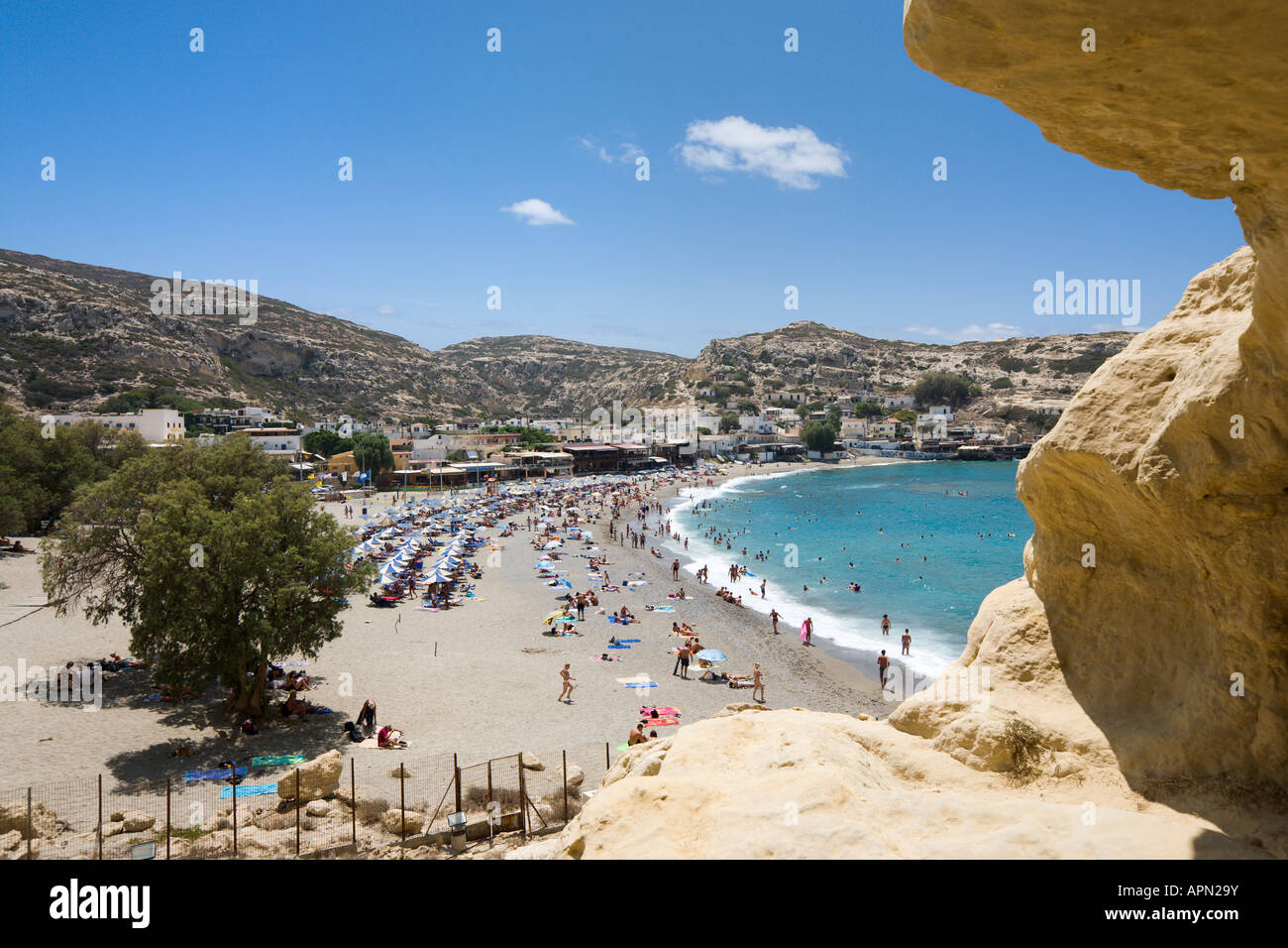 Vista sulla spiaggia e il villaggio dalla scogliera e grotte, Matala, South Coast, Provincia di Iraklion, Creta, Grecia Foto Stock