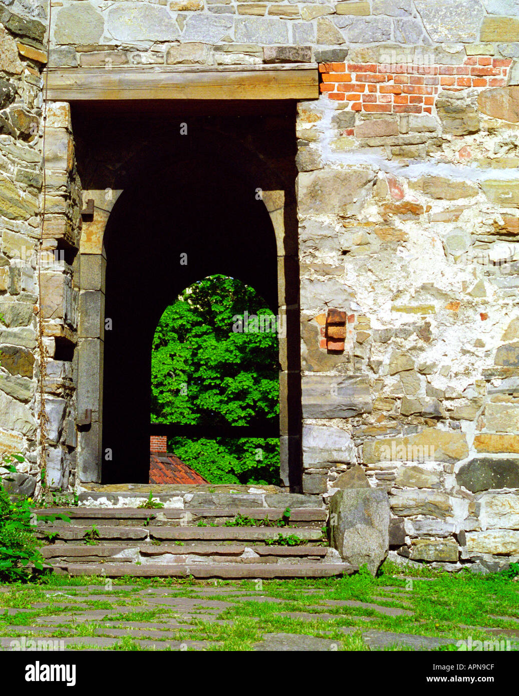 Porta nel muro di pietre misti in castello di Oslo Norvegia Foto Stock