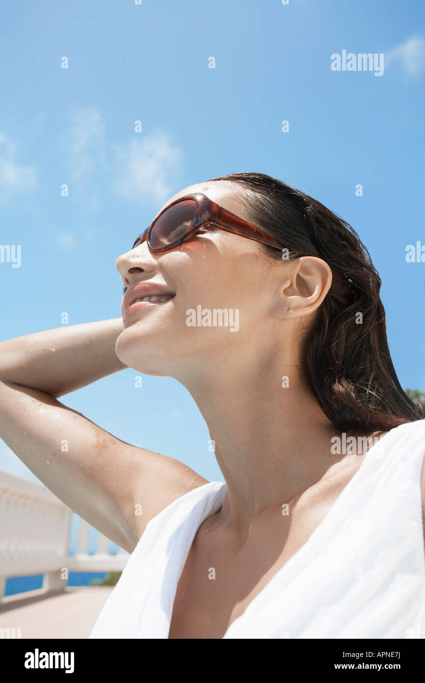 Giovane donna che indossa gli occhiali da sole (basso angolo di visualizzazione) Foto Stock