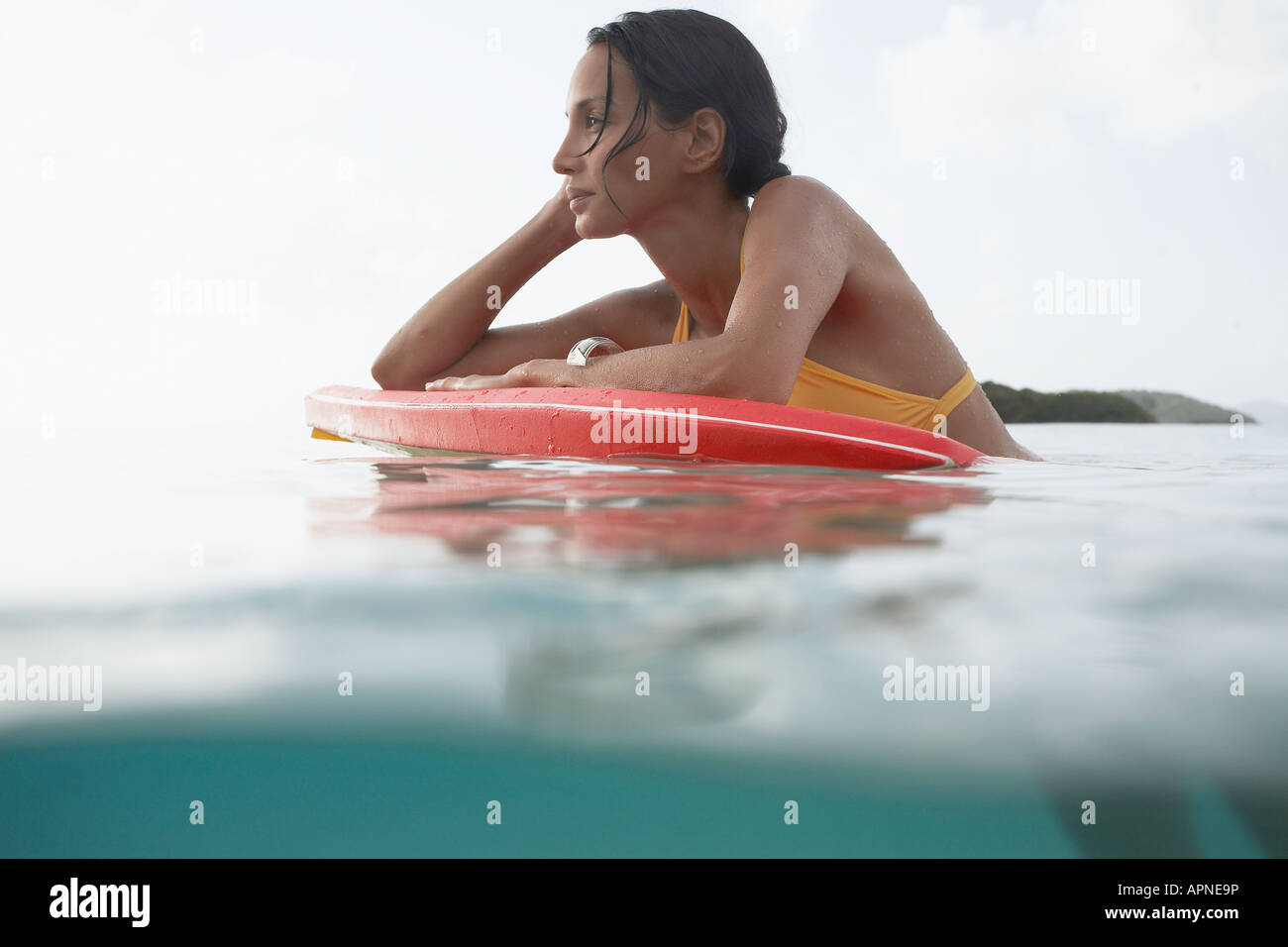 Giovane donna che guarda la vista sul bodyboard (superficie di livello) Foto Stock