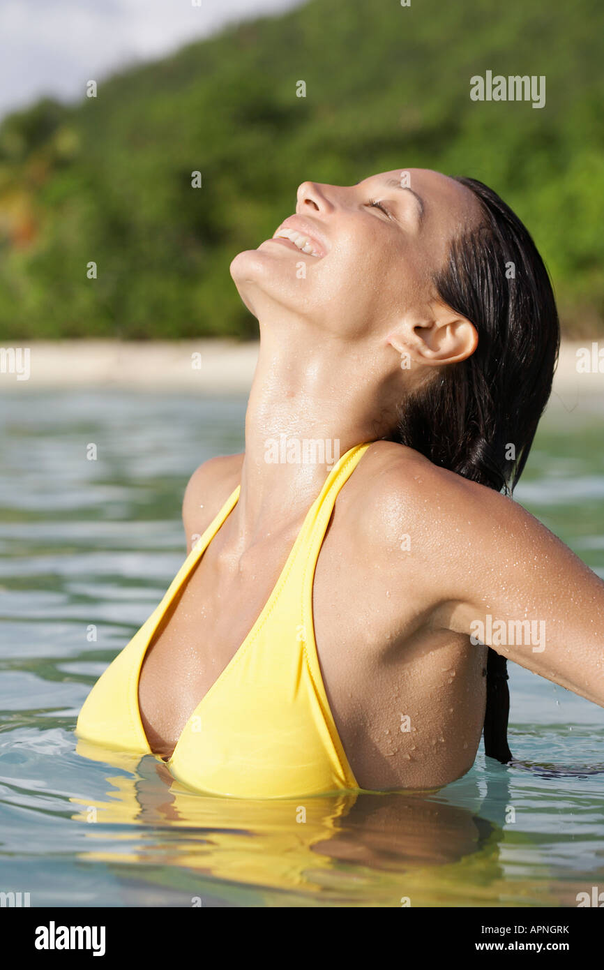 Giovane donna in piedi profondo in acqua con gli occhi chiusi Foto Stock