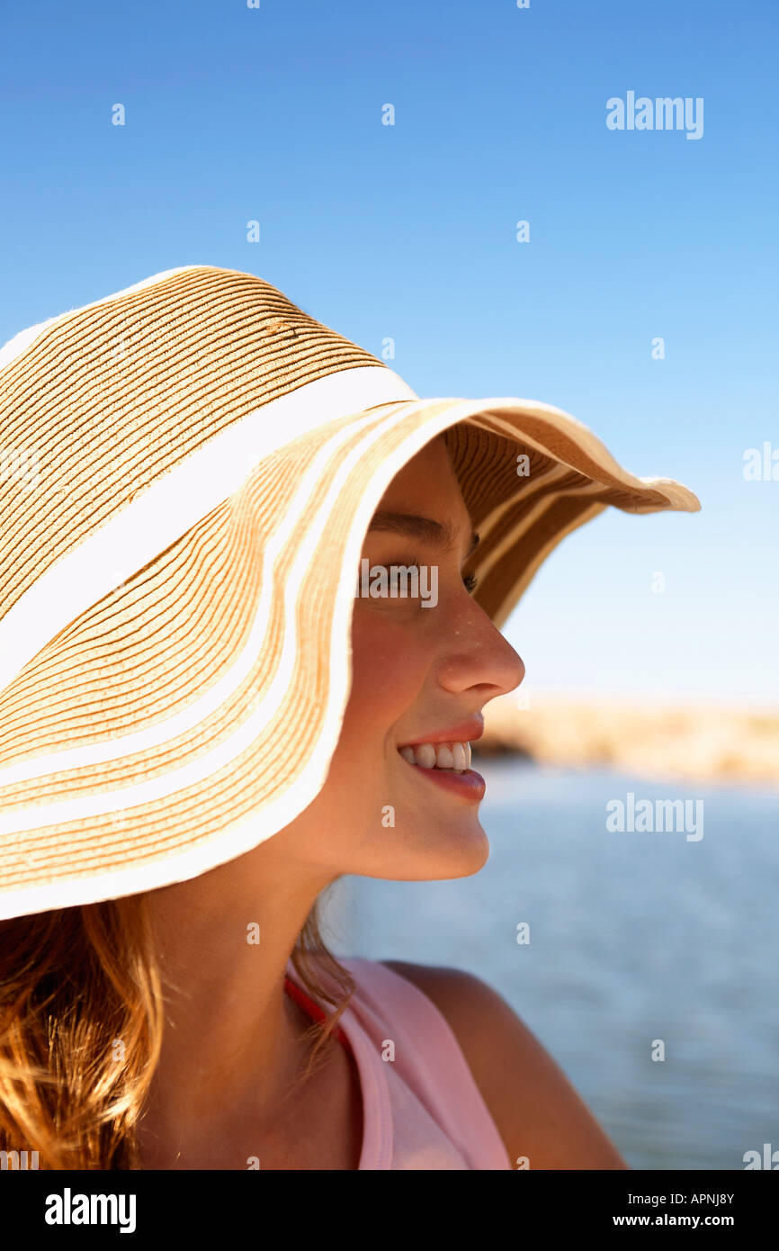 Giovane donna nel cappello per il sole al lago Foto Stock