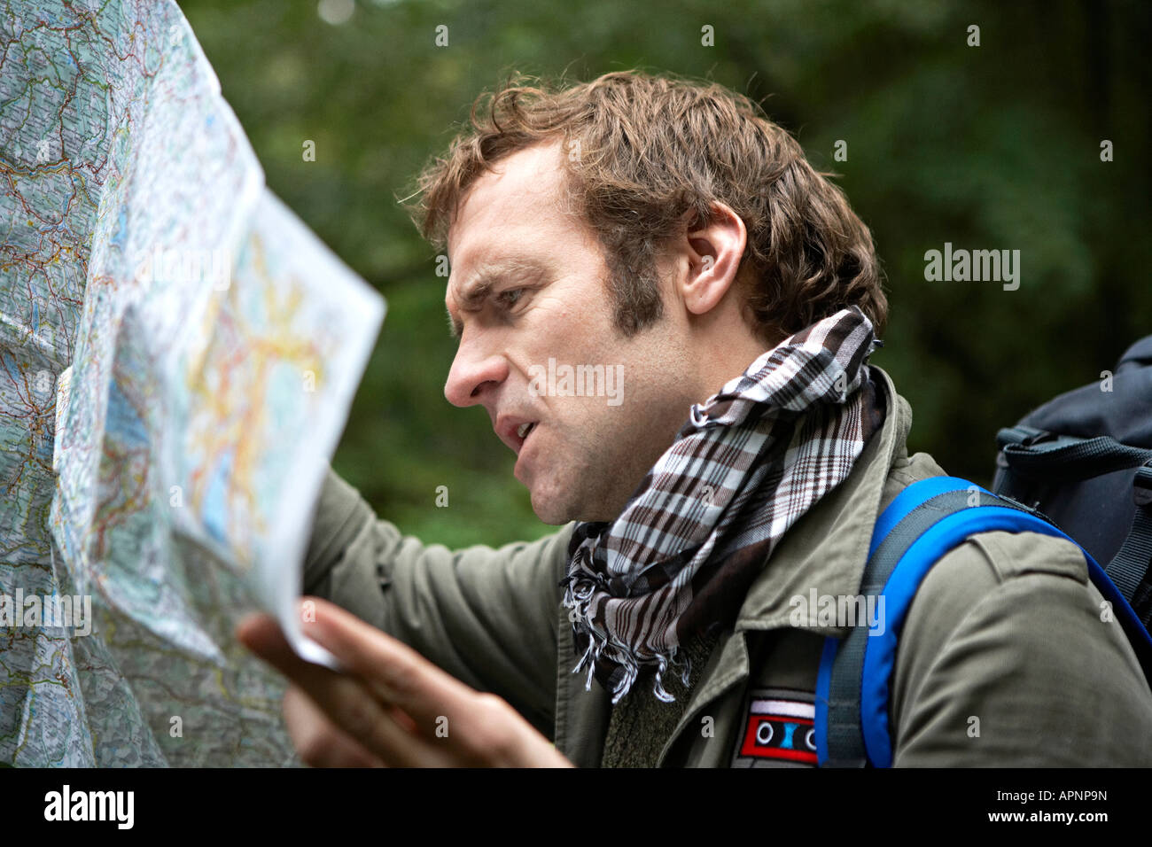 Escursionista maschio Mappa di lettura nella foresta Foto Stock