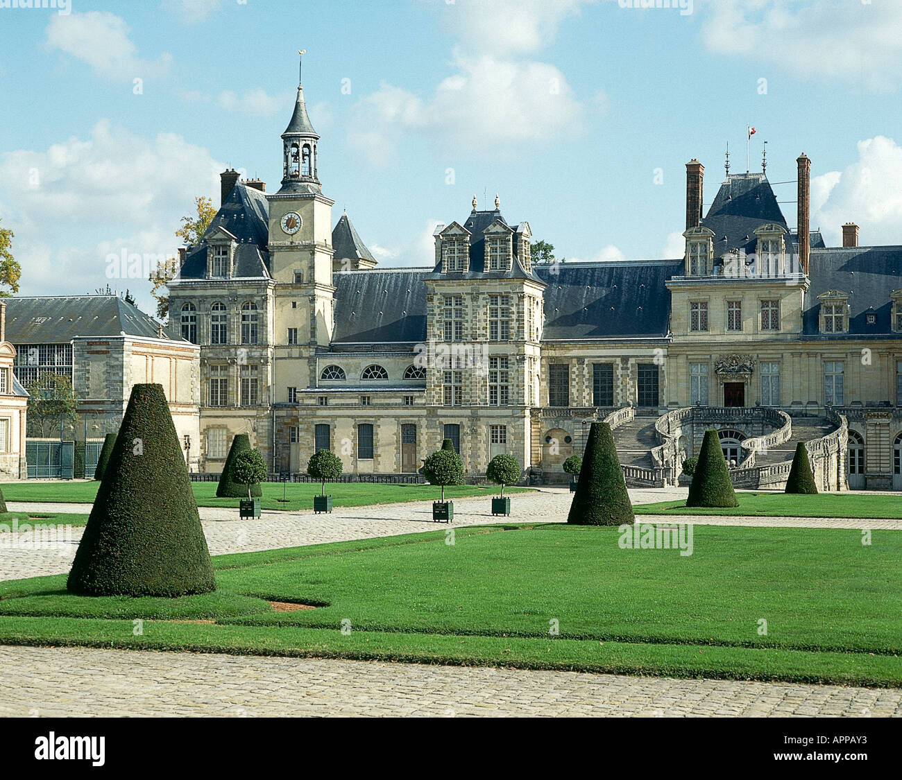 Cerca passato tagliati a forma conica alberi verso il Chateau de Fontainbleau risalente al XII secolo con molte aggiunte e modifiche fino al XIX secolo Foto Stock