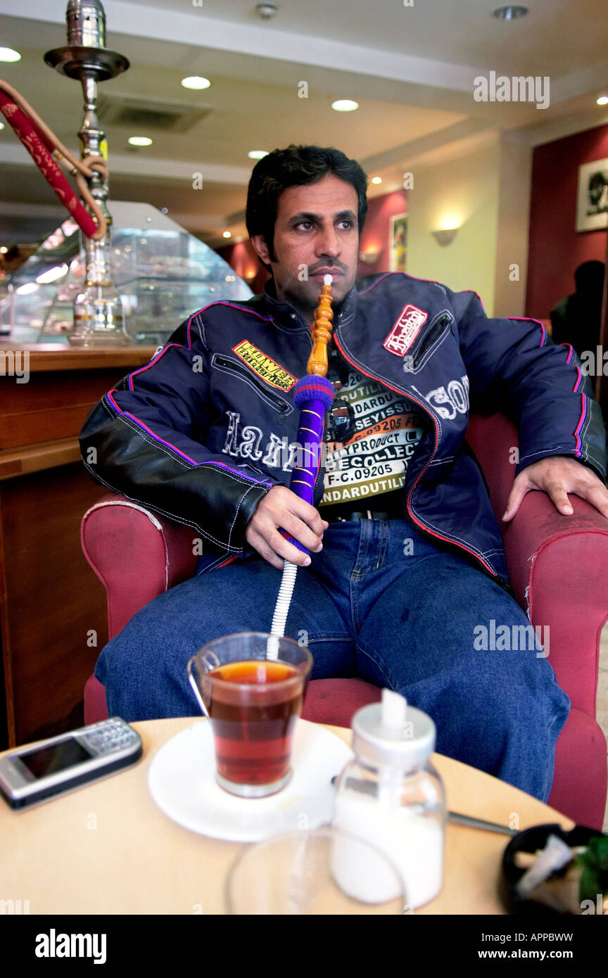 Un uomo di fumare un narghilè in un cafe su Edgware Road Londra Foto Stock