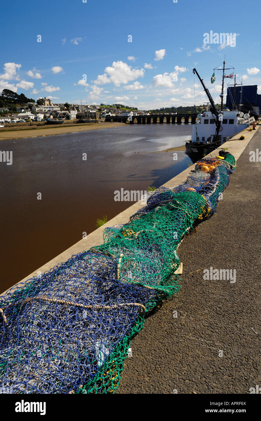 Le reti da pesca sulla banchina a Bideford Porto. Il XIII secolo Bideford lungo ponte nella distanza si estende al di là del fiume Torridge a est-del-l'acqua. Il Lundy traghetto, MS Oldenburg, può essere visto ormeggiate lungo la banchina. Devon. Foto Stock