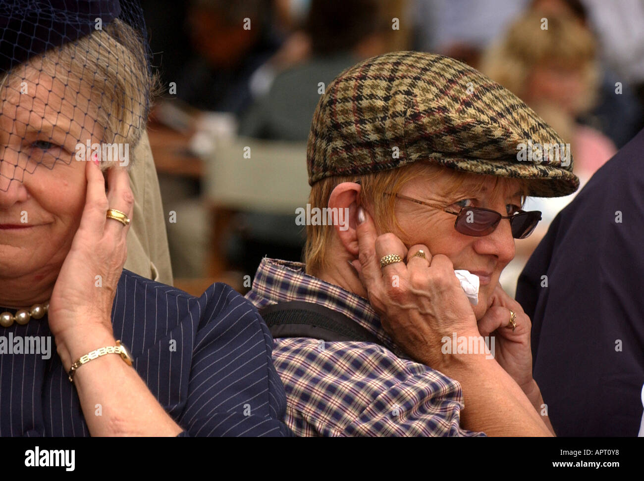 La donna con le dita nella loro orecchie a Goodwood Motor Racing circuito. Foto da Jim Holden. Foto Stock