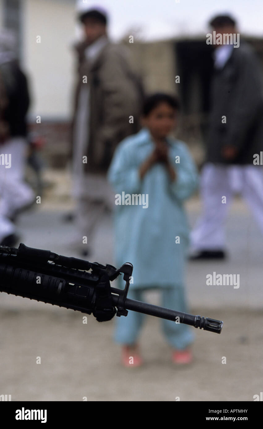 Oriente Afghanistan Gennaio 2005 noi soldati dell esercito in base a Khost - un soldato con una pistola passeggiate passato alcuni uomini locali Foto Stock