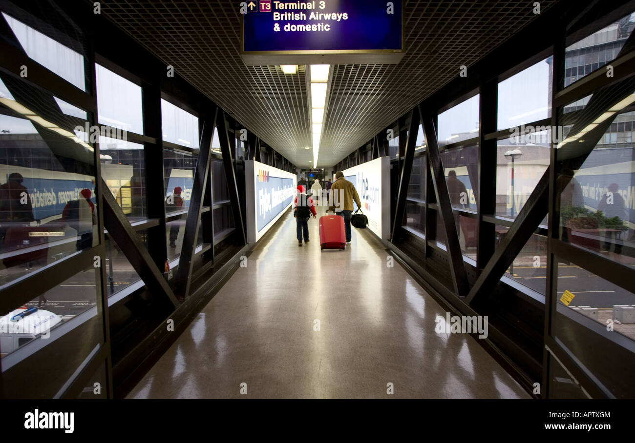 Passeggeri a piedi verso il basso e verso la porta d'imbarco del terminal 3 dell'Aeroporto Internazionale di Manchester a Manchester REGNO UNITO Foto Stock