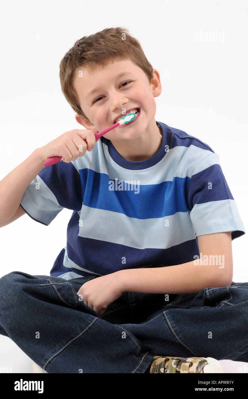 Un giovane bambino spazzolando i suoi denti Foto Stock