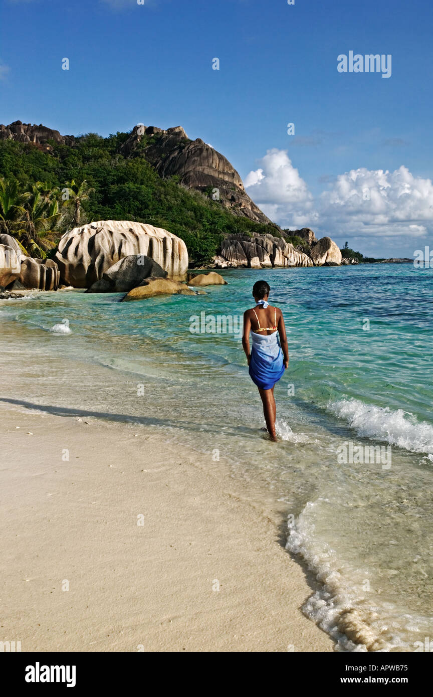 Donna che cammina sulla spiaggia Modello rilasciato Anse Source d Argent beach La Digue Island Seychelles Foto Stock