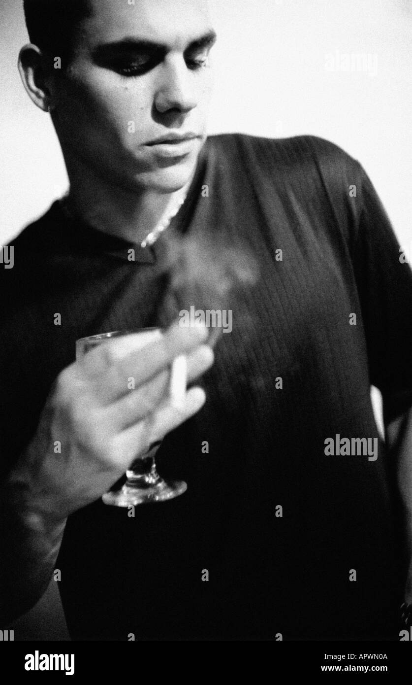 Uomo in possesso di una sigaretta e bicchiere di vino Foto Stock